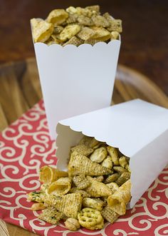 two paper containers filled with cereal on top of a table