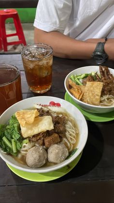 two bowls of food on a table with drinks