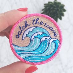 someone is holding up a patch with the words, save the waves on it and an ocean wave