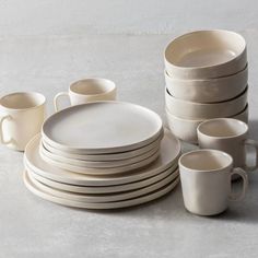 a stack of plates and cups sitting on top of a table next to each other