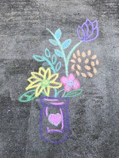 a chalk drawing of flowers in a jar on the ground with colored chalks and crayons