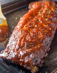 ribs covered in bbq sauce with a wooden spatula