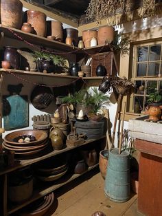 a room filled with lots of pots and pans on shelves next to each other