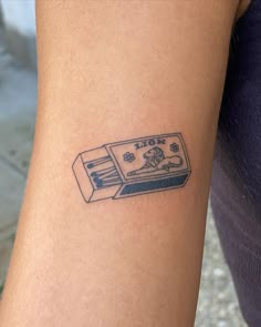 a tattoo on the arm of a person with a video game controller in front of them