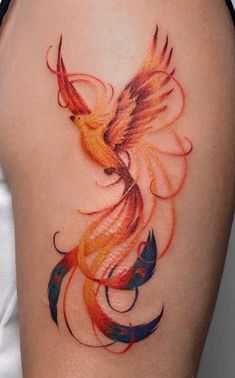 a woman's thigh with a bird tattoo on her leg and an orange, red, yellow and blue design