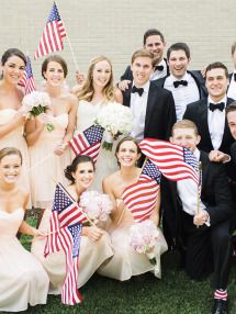 a group of people in formal wear posing for a photo with american flags and flowers