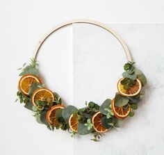 an arrangement of orange slices and greenery arranged in a circle