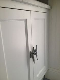 a white cabinet with two doors and some knobs on the door handle is shown