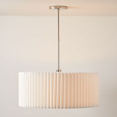 a white lamp hanging from a ceiling fixture in a room with no one around it