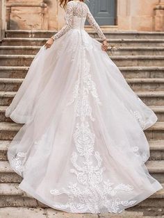 a woman in a wedding dress standing on some steps