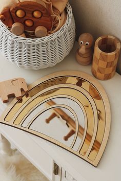 wooden toys are sitting on a table next to a basket and other items in front of it