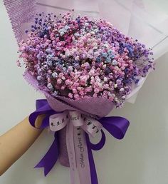 a bouquet of flowers is wrapped in purple paper