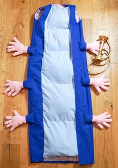 two hands are on the floor next to a sleeping bag that has been folded over