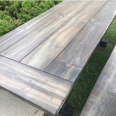 two wooden benches sitting next to each other on top of a grass covered park bench