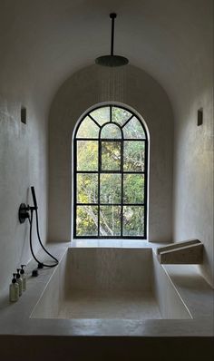 a large bath tub sitting under a window next to a faucet