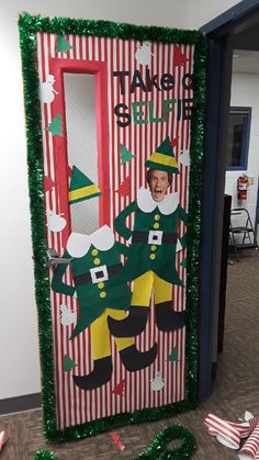 a door decorated to look like an elf with green and red stripes on the side