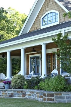 a house that has some plants in the front yard and bushes on the side of it