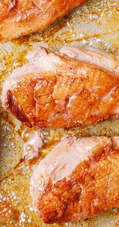 pork chops cooking in a skillet with mustard and seasoning on the side