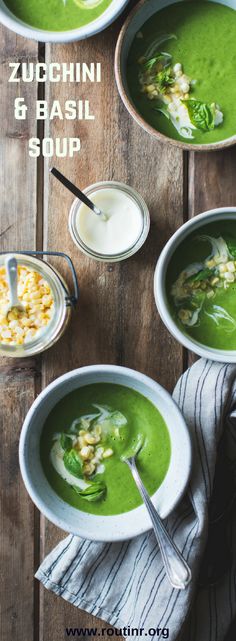 three bowls filled with green soup on top of a wooden table next to spoons