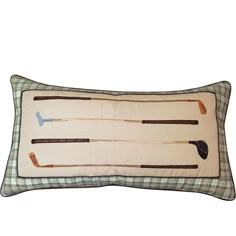 an embroidered pillow with three golf clubs on the front and two arrows on the back