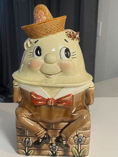 a ceramic figurine with a hat and bow tie