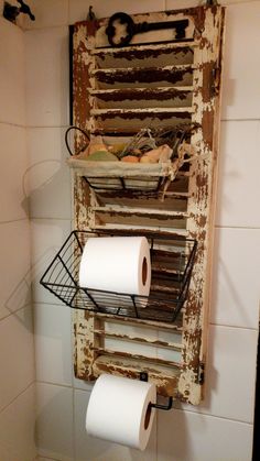 an old wooden rack holding two rolls of toilet paper