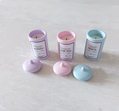 three small candles sitting next to each other on a white counter top with one candle in the middle