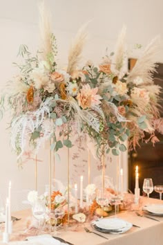 the table is set with flowers, candles and place settings for an elegant dinner party