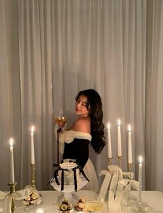 a woman standing in front of a table with candles