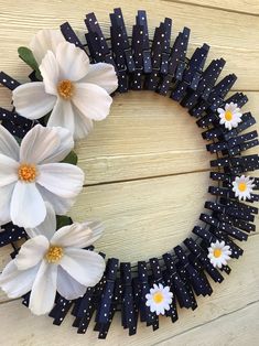 a wreath made out of black and white paper flowers on a wooden surface with polka dots