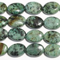 several green and brown stones on a white surface