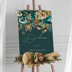 an easel with flowers and greenery on it