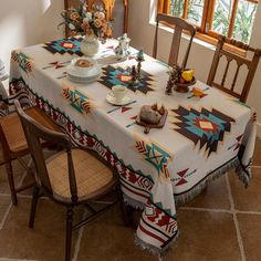 a dining room table covered with a blanket and place settings for two people sitting at it