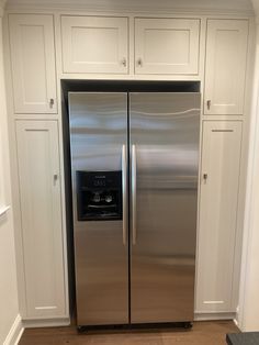 a stainless steel refrigerator in a white kitchen