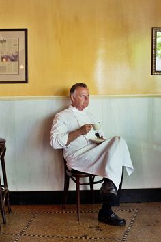 a man sitting in a chair holding a plate