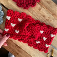 two crocheted hearts are sitting on a table