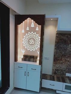 a kitchen with white cabinets and an intricate design on the wall