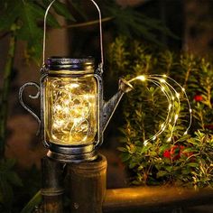 a light that is sitting on top of a table next to some plants and flowers