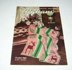 an advertisement for afghans featuring deer on pink and green striped blanket with flowers in the background