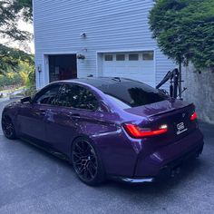 a purple car parked in front of a garage