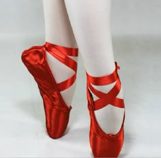 a close up of a person wearing red ballet shoes