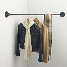 a coat rack with scarfs and jackets hanging on it