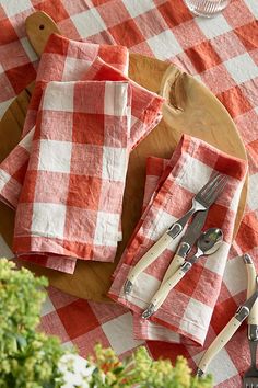 red and white checkered table cloths with utensils on a cutting board