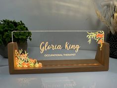 a wooden stand with an illuminated sign that says, gloria king international therapiest