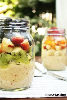 two mason jars filled with food sitting on top of a table