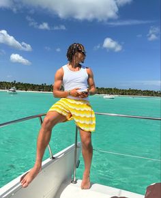 a man sitting on top of a boat in the ocean