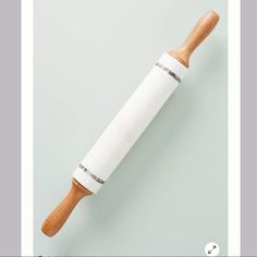 a wooden rolling pin sitting on top of a white table next to a gray wall