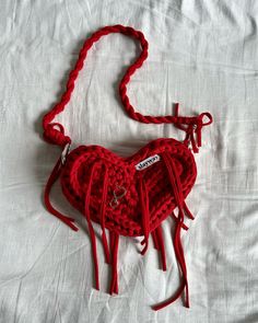 a red crocheted purse on a white sheet