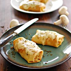 two small pastries on a plate with a knife and fork