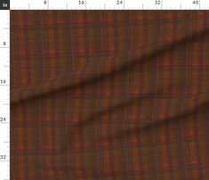 a brown and red plaid fabric with a ruler in the foreground to show it's length